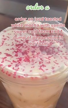 there is a drink with white and red sprinkles in the foam on it