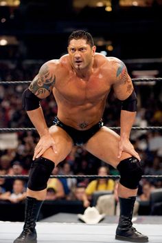 the wrestler is posing in his wrestling ring for a photo while holding his hands on his knees