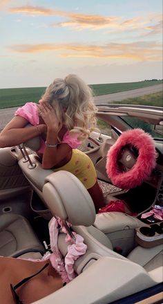 a woman sitting in the driver's seat of a car with her hand on her face