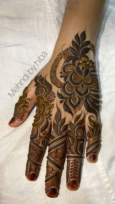 a woman's hand with henna tattoos on it