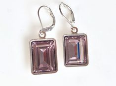 Handset emerald cut Swarovski jewel into silver-plated dangles. The shade is called light amethyst which is a very pale lavender hue. Each hangs on matching lever back ear wires for a glamorous red carpet look. The total length of the earrings is a little less than 1.5" long. Perfect for a special occasion or everyday bling. The third picture is for sizing purposes and is in a darker shade. Copyright ©, all rights reserved. LoveYourBling® is an authorized SWAROVSKI® Crystals Branding Partner. Luxury Faceted Purple Earrings, Rectangular Crystal Earrings For Gifts, Elegant Jewelry With Rectangular Pendant And Matching Earrings, Nickel-free Crystal Earrings For Formal Occasions, Silver Crystal Earrings With Gemstones, Elegant Amethyst Dangle Crystal Earrings, Faceted Crystal Earrings For Formal Occasions, Formal Nickel-free Crystal Earrings, Purple Rectangular Jewelry For Party