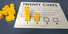 two yellow cubes sitting on top of a piece of paper