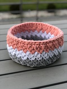 a crocheted bowl sitting on top of a wooden table