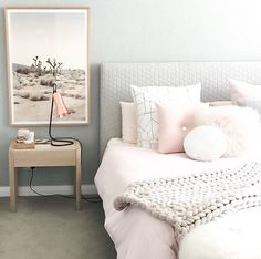 a white bed sitting in a bedroom next to a painting