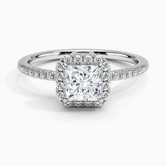 an engagement ring with a square cut diamond surrounded by pave diamonds