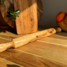 a wooden rolling pin sitting on top of a cutting board