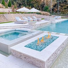 an outdoor swimming pool with fire pit and lounge chairs in the backround area