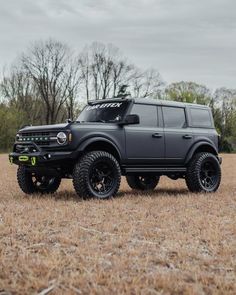 a black truck parked in the middle of a field