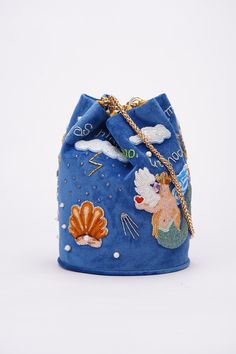 Handbag to pre-order. Production time 2-3 weeks. Bag of the purse model, made of blue velvet, on the lining. It has the shape of a bag with a rounded bottom. Hand-embroidered with Czech beads and Preciosa glass beads.  The handle is 60 cm long. The diameter of the bottom of the handbag (width) is 18.5 cm, height is 24 cm. Born of the rainbow, nurtured by the thunder, the nymph Stella develops her song. Her voice pours over the clouds and falls on the grass, flowers, trees and all living things in the form of rain drops. She has an impossible dream - to fly to the star. Not so far from it, just 10 light-years away in outer space lives an amazing shell. She knows how to show desire, but taking something in return for it.Once every 1,000 years, the conch came down to the Nymph to listen to he Designer Blue Bucket Bag, Luxury Bucket Shape Bag For Gift, Designer Blue Bucket Bag With Dust Bag, Blue Luxury Pouch Bucket Bag, Luxury Blue Pouch Bucket Bag, Luxury Blue Shoulder Bucket Bag, Luxury Blue Bucket Bag, Luxury Bucket Shape Shoulder Bag As Gift, Luxury Bucket-shape Shoulder Bag As Gift