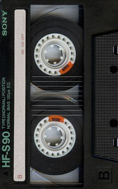 two black cassettes with white rims are stacked on top of each other,