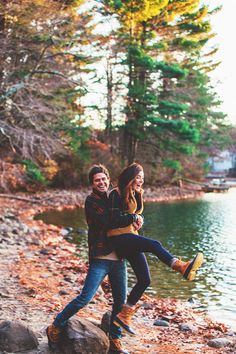 a man carrying a woman on his back by the water