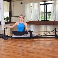 a woman is sitting on the floor doing yoga