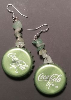 coca cola bottle cap earrings with green glass beads and silver earwires on black background