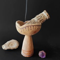 a wooden bowl sitting on top of a table next to a rock