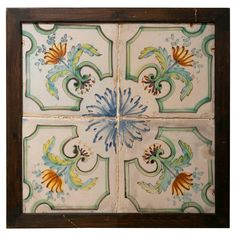 an artisticly painted tile design is shown in the center of this square piece, which has been framed by wood