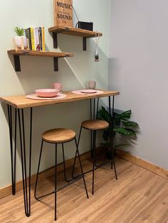 two wooden tables sitting next to each other on top of a hard wood floored floor