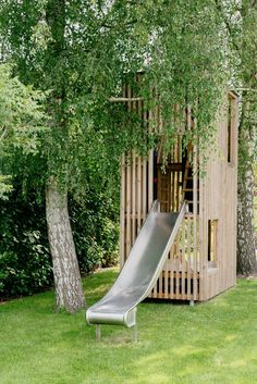 a wooden structure with a slide in the grass