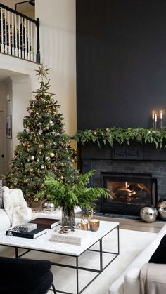 a living room filled with furniture and a christmas tree in front of a fire place