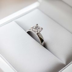 an engagement ring in a white box