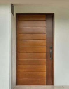 a wooden door in front of a white wall