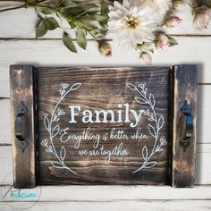 a wooden sign that says family everything is better when you are together with flowers in the background