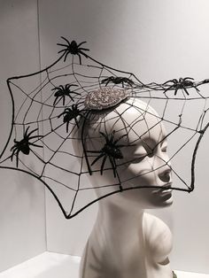 a white mannequin head with spider webs on it