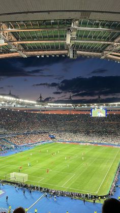 a large stadium filled with lots of people sitting on the bleachers watching a soccer game