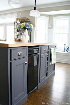 a kitchen with gray cabinets and wood floors