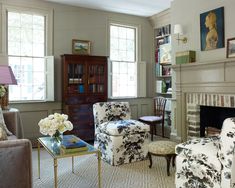 a living room filled with furniture and a fire place in front of a fireplace covered in bookshelves