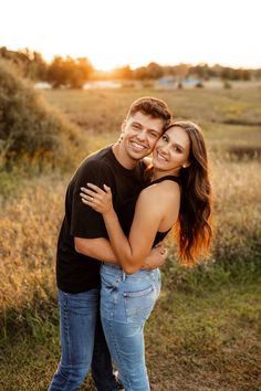 a young man and woman embracing each other in an open field