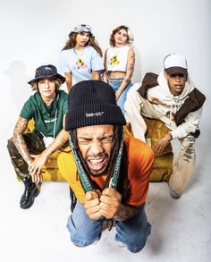 a group of young men and women sitting on top of a couch with their mouths open