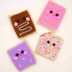 three crocheted toasters with faces on them, one is pink and the other is brown