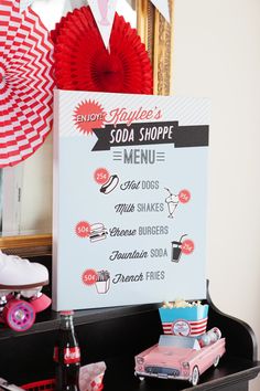 there is a sign that says soda shoppe menu on the table with other items