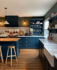 a kitchen with blue cabinets and wooden floors