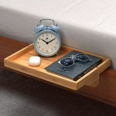 an alarm clock sitting on top of a wooden tray