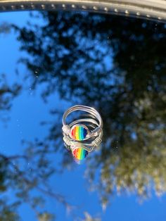 This is a handmade wire ring with a rainbow pride stone. This comes in a variety of sizes and band colors. Made in Arizona. Adjustable Rainbow Sterling Silver Jewelry, Unique Rainbow Colored Rings As Gift, Unique Rainbow Rings As Gift, Unique Rainbow Rings For Gifts, Rainbow Wire Wrapped Round Jewelry, Handmade Rainbow Colored Ring Jewelry, Handmade Rainbow Jewelry Ring, Handmade Rainbow Ring Jewelry, Adjustable Multicolor Crystal Promise Ring