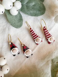 three pairs of earrings sitting on top of a table