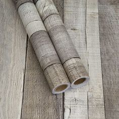 two rolls of wood sitting on top of a wooden floor