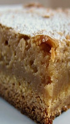 a close up of a piece of cake on a plate with powdered sugar around it