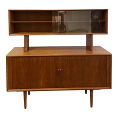 a wooden entertainment center with glass doors on the top and bottom shelf, against a white background