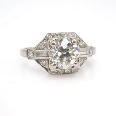 A perfect Art Deco engagement ring. A 1.75 ct Old European Cut diamond (G VS2) is flanked on either side by a baguette diamond (0.14 ct total, F VS1). The entire ring is outlined by 0.30ct of F VS2 round diamonds, bringing the total carat weight to 2.19 ct. The ring is made of platinum.We must say, it is rare to find a high color, high clarity stone and have it be an old fashioned cut. When the modern brilliant first arrived, a lot of people took their good diamonds and had them recut in an effo Timeless Octagon Platinum Diamond Ring, Octagon Brilliant Cut Diamond Ring, Brilliant Cut Octagon Diamond Ring, Timeless Diamond Cut Baguette Diamond Ring, Timeless Gia Certified Baguette Cut Diamond Ring, Timeless Baguette Cut Gia Certified Diamond Ring, Timeless Baguette-cut Diamond Ring, Gia Certified Baguette Cut White Gold Diamond Ring, Classic Octagon Diamond White Diamond Ring