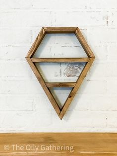 a wooden shelf sitting on top of a white brick wall