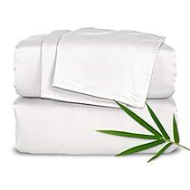 two white sheets with bamboo leaves on them and one is folded up in front of the other