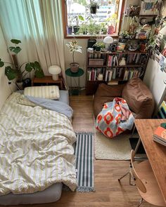 a small bedroom with a bed, desk and bookshelf in the corner next to a window