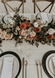 the table is set with flowers and silverware