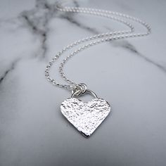 Handmade Sterling Silver Hammered Heart Necklace  ℹ️TECHNICAL INFO: Handmade in my Northumberland workshop (UK) from 100% recycled sterling silver. Hammered/Polished finish. Suspended on a sterling silver belcher chain that catches the light beautifully. Eleven Feathers Jewellery ~ Crafting celestial magic for your body and soul✨ 🎁PACKAGING: All my products are immediately giftable as they are. Lovingly packaged and no sales details in the box. Jewellery comes in a cotton gift bag with care ins Artisan Silver Necklace With Heart Charm, Handmade Sterling Silver Heart Pendant Necklace, Artisan Sterling Silver Heart Necklace, Artisan Heart-shaped Sterling Silver Necklace, Handmade Sterling Silver Heart Necklace, Feather Logo, Heart Necklace Silver, Sparkly Necklace, Niece Gifts