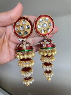 Multi tiered/layered red Meenakari jhumkas. These are Handpainted ones with Kundan stones on it. The 4 tiers make it one of a kind. The tops portion is almost like a quarter size coin which makes it sturdy and it stays upright. The hanging with ivory pearls with red Meena work makes it very pretty. Simple push back closure. A complete statement piece in itself. Almost 4 inches in length. Meenakari Jhumkas, Bridal Necklace Set, Ivory Pearl, Mala Beads, Red Stone, Bridal Necklace, White Ring, Indian Jewelry, Matching Earrings