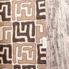 a brown and white area rug sitting on top of a wooden floor next to a wall