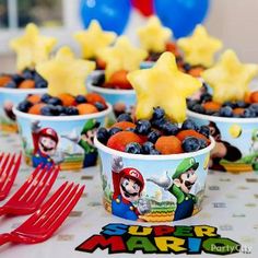 super mario birthday party food cups and forks on a table with balloons in the background