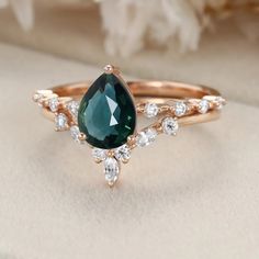 Elevate your love story with our Pear Shaped Lab Blue Green Sapphire and Moissanite Engagement Ring Set in Rose Gold—an exquisite symbol of love and commitment that's sure to captivate your heart.
At the heart of this set is a pear-shaped lab blue-green sapphire, known for its mesmerizing and unique color. Paired with brilliant moissanite accents, this set sparkles with every glance. Moissanite Engagement Ring Set, Blue Green Sapphires, Pear Shaped Engagement Rings, Colored Engagement Rings, Green Sapphire, Engagement Ring Set, Emerald Ring, Engagement Ring Settings, Lab Diamonds